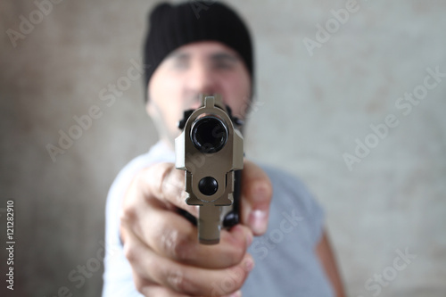 armed robber pointing the gun at the target