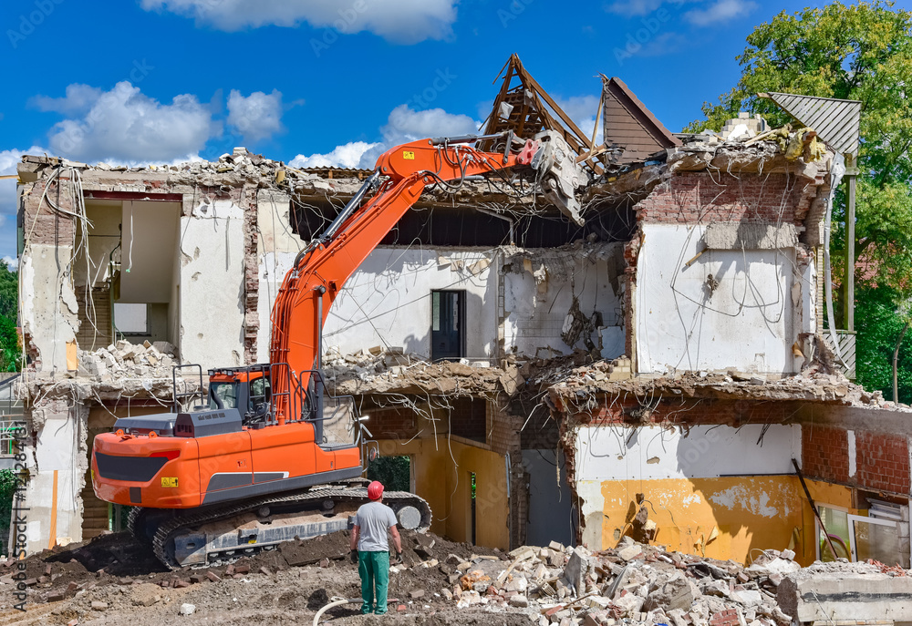 Baumaschine im Einsatz - Abbrucharbeiten an einem Haus Baumaschine im Einsatz - Abbrucharbeiten an einem Haus
