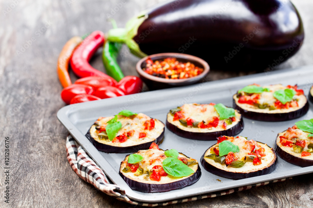 Baked  eggplant with cheese and tomatoes on baking tray