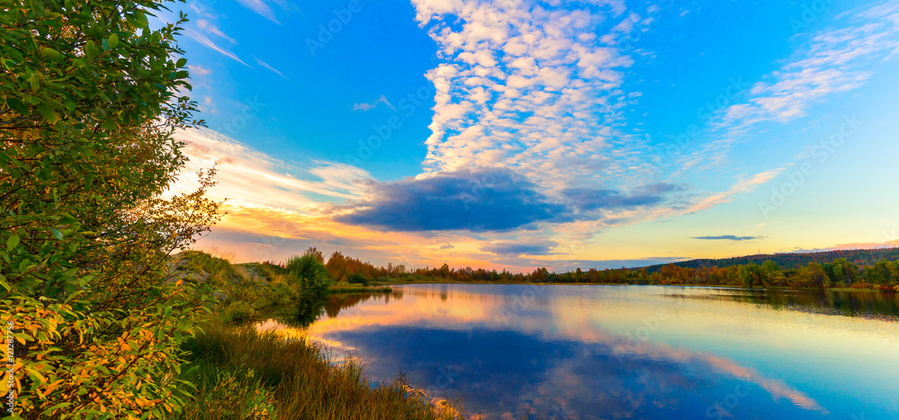 Autumn landscape.Sunset sky over the lake in the autumn forest