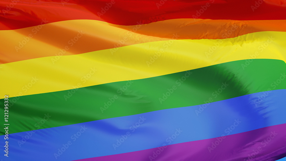 Obraz premium The gay pride rainbow flag waving against clean blue sky, close up, isolated with clipping path mask alpha channel transparency
