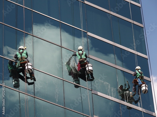 man cleaning glass building