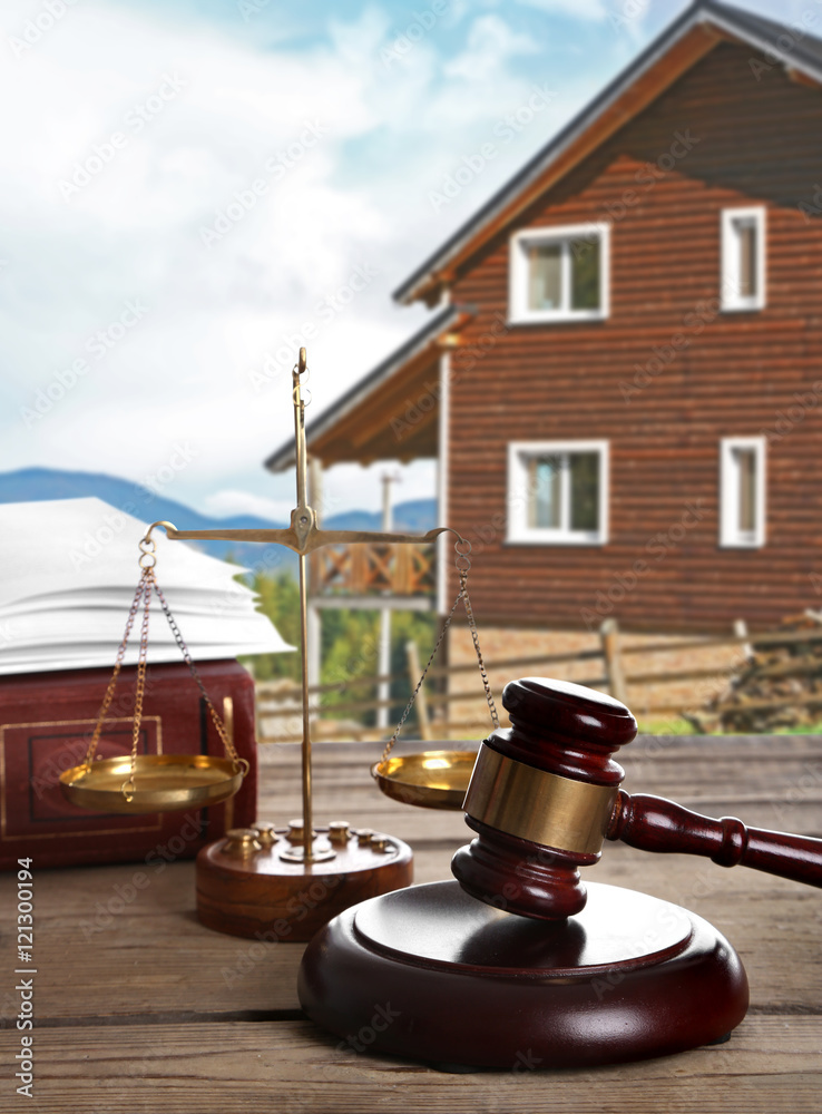 Gavel on wooden house background Gavel on wooden house background
