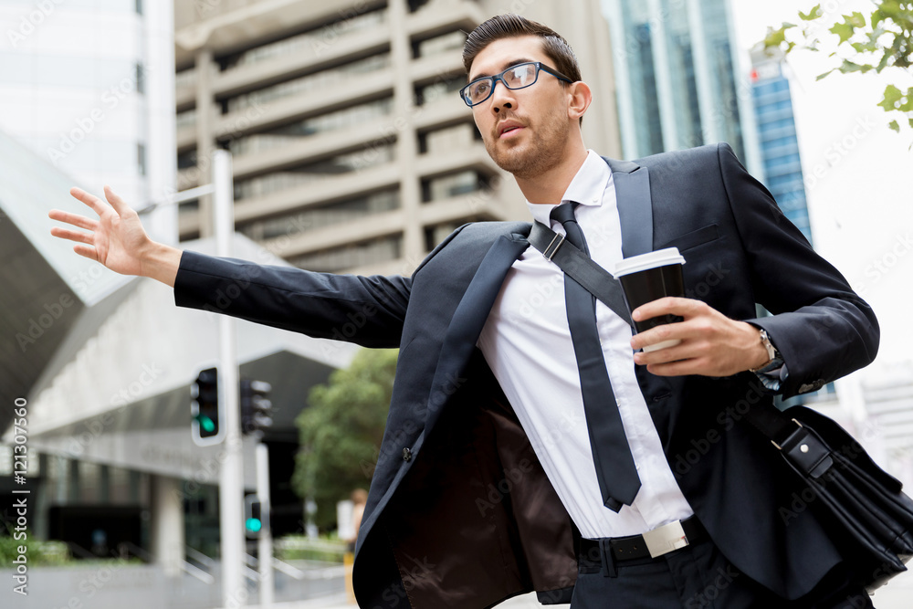 Young businessman hailing for a taxi Young businessman hailing for a taxi