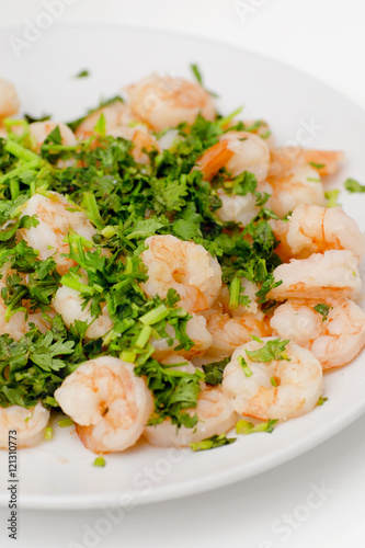 Fried shrimps with the greens. Easy seafood snack on white background close-up.