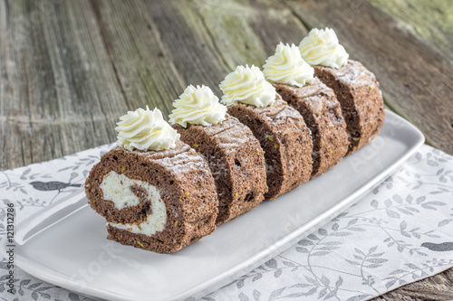 Five pieces Chocolate roulade filled with whipped cream on white