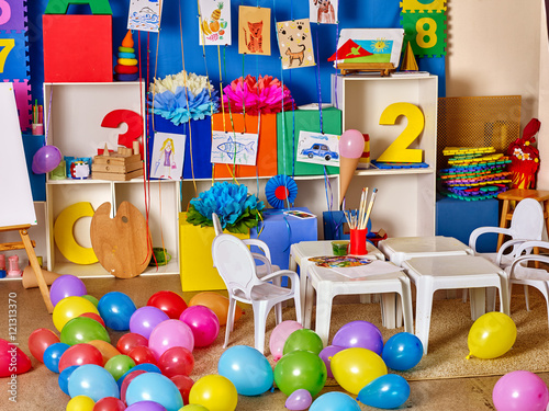 Interior of game room in preschool kindergarten. A lot of balloons on floor.