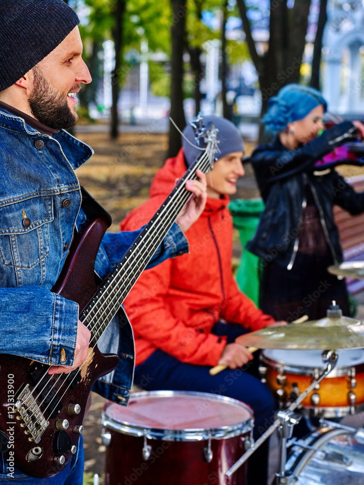 Group of music street performers with girl violinist on autumn outdoor. Music people play drums. Group of music street performers with girl violinist on autumn outdoor. Music people play drums.