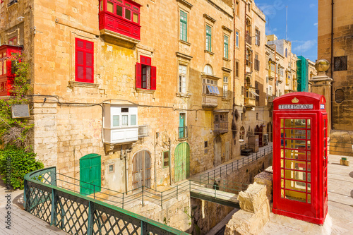 Valletta, Malta - Streetview with traditional british red phone box and red Maltese balconies  © zgphotography