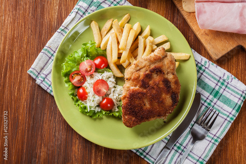 Cutlet Cordon Bleu with pork loin served with French fries and s photo