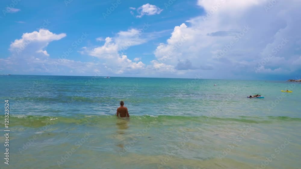 Happy male tourist antering tropical sea in Thailand Happy male tourist antering tropical sea in Thailand