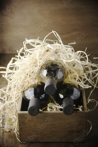 Wine bottles in wooden box and straw