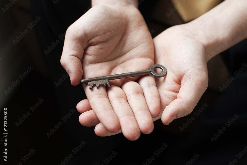 Hands holding old key