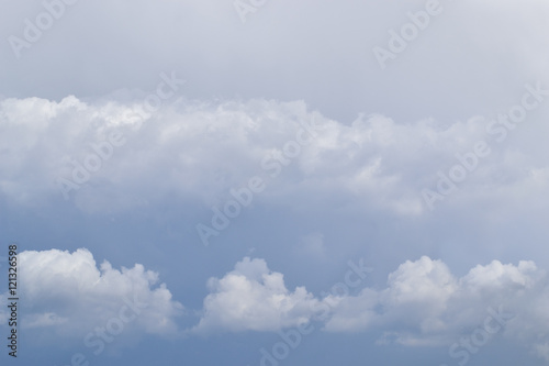 Fototapeta Naklejka Na Ścianę i Meble -  Cloudy sky. Background.
The chain of white clouds on a background of dark rain clouds.