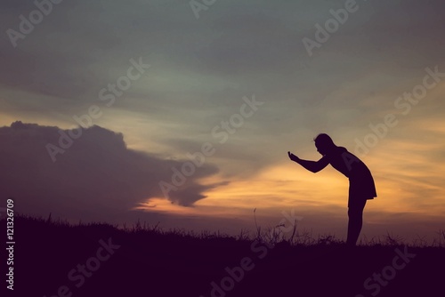 silhouette of woman Standing blessings of god at sunset