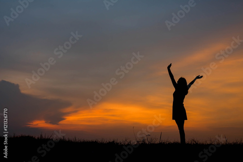 silhouette of woman  enjoys outdoor at sunset