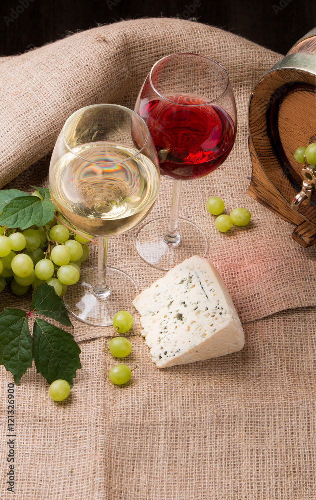 Wine glasses with red, white and rose. Cheese on nature table with fresh grapes 