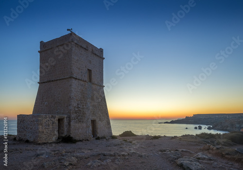 Malta, Ghajn Tuffieha Tower at sunset with clear blue sky at Golden Bay