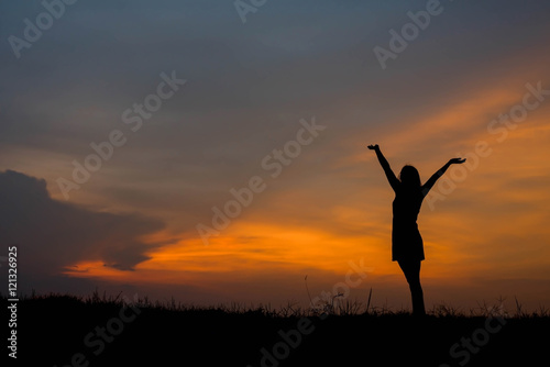 silhouette of woman  enjoys outdoor at sunset © stcom