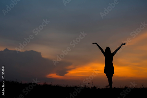 silhouette of woman enjoys outdoor at sunset