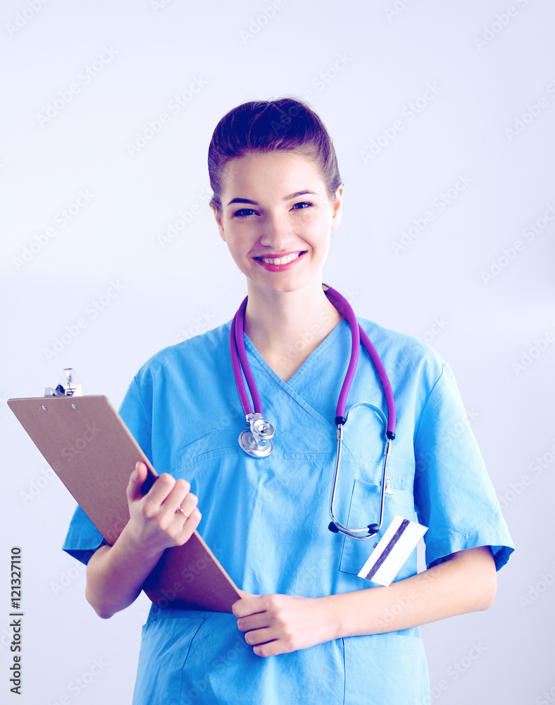 Smiling female doctor with a folder in uniform standing at hospital Smiling female doctor with a folder in uniform standing at hospital