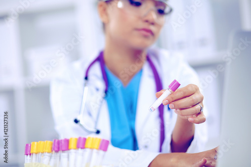 Woman researcher is surrounded by medical vials and flasks  isolated on white background