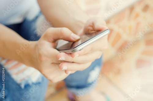 Close up of women's hands holding cell telephone, hipster girl watching video on mobile phone.
