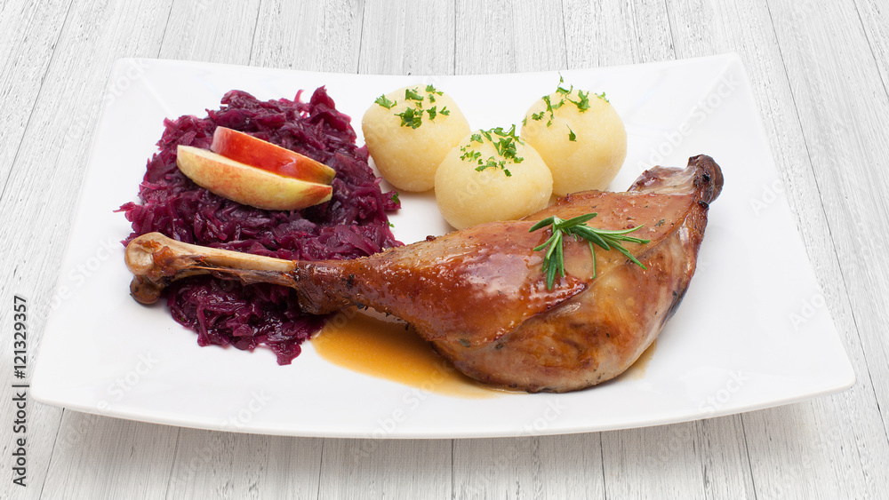 Gänsekeule mit Rotkohl und Klößen auf weißem Holzuntergrund Stock-Foto ...