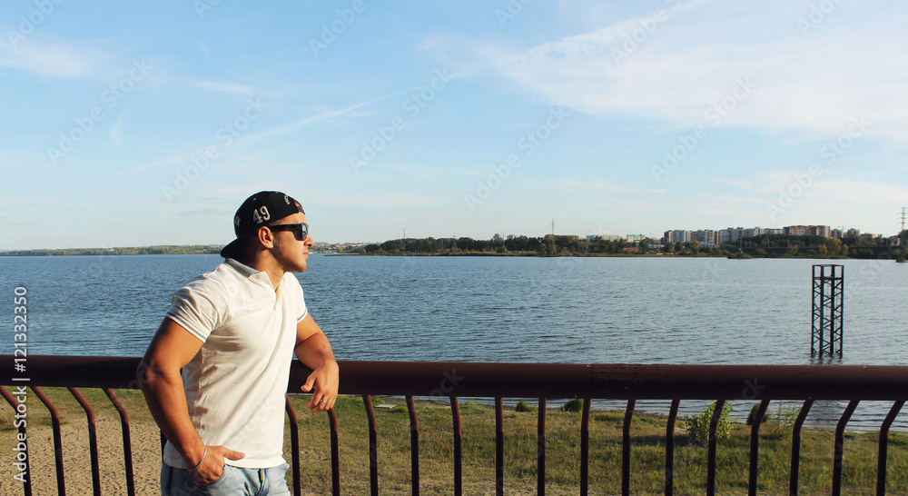 A man looks at sea off the fence