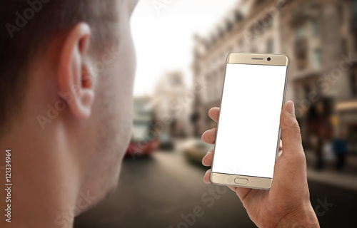 Man holding phone on city street. Isolated white display for mockup. photo