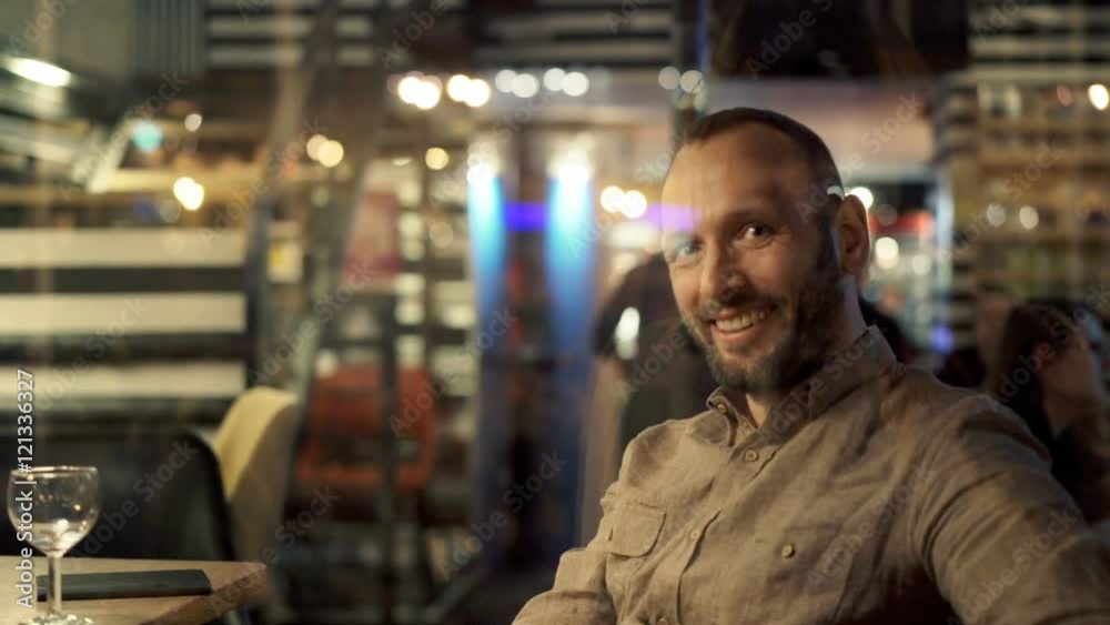 Portrait of happy, handsome man sitting in cafe during evening
Portrait of happy, handsome man sitting in cafe during evening