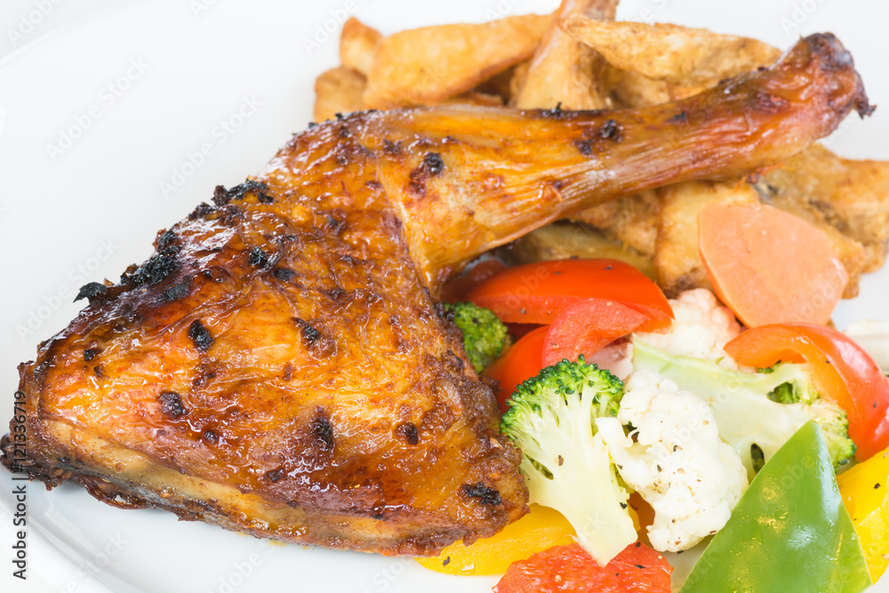 Roast chicken thigh with potato wedges and sauteed vegetables Roast chicken thigh with potato wedges and sauteed vegetables