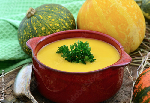 Kürbissuppe in Suppentasse / Kürbise auf Holz mit Löffel / Nahaufnahme / Foodstyling  photo