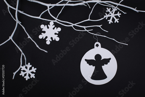 Christmas paper angel and snowflake decoration hanging over blac photo