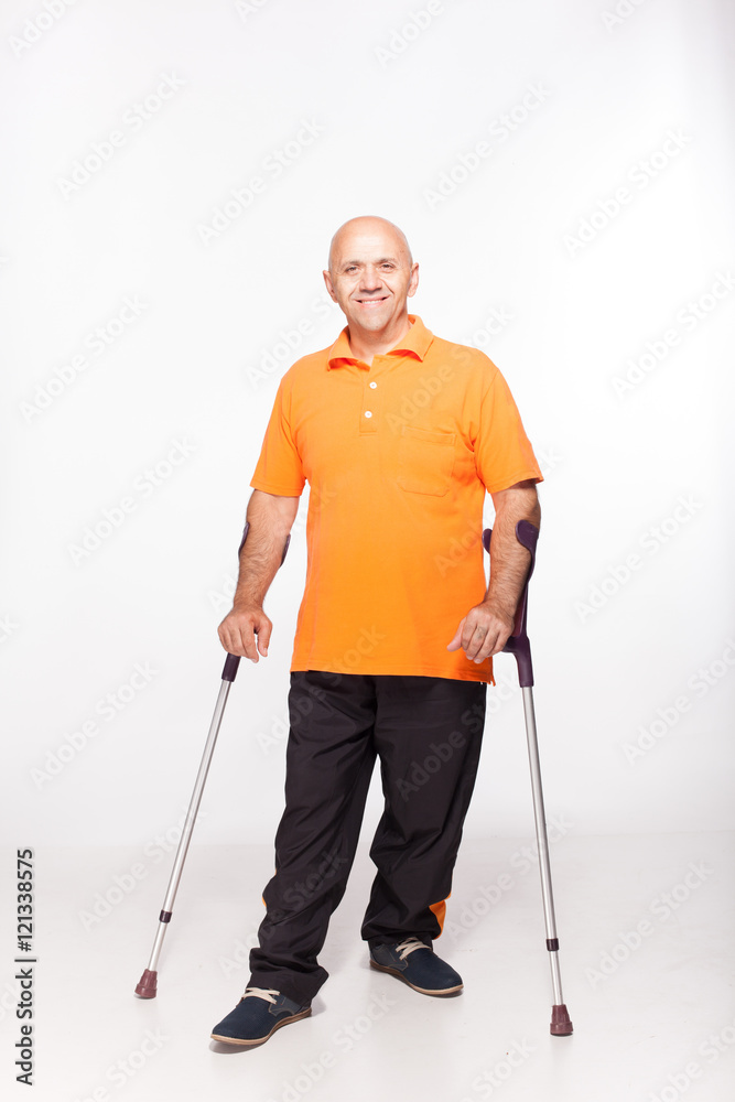 A man stands on crutches disabled. Isolated on white. A man stands on crutches disabled. Isolated on white.