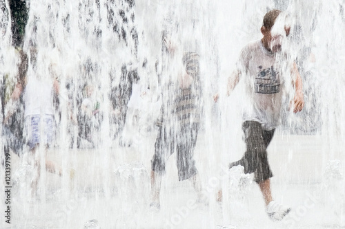 Fototapeta Naklejka Na Ścianę i Meble -  Children playing in street water fountains