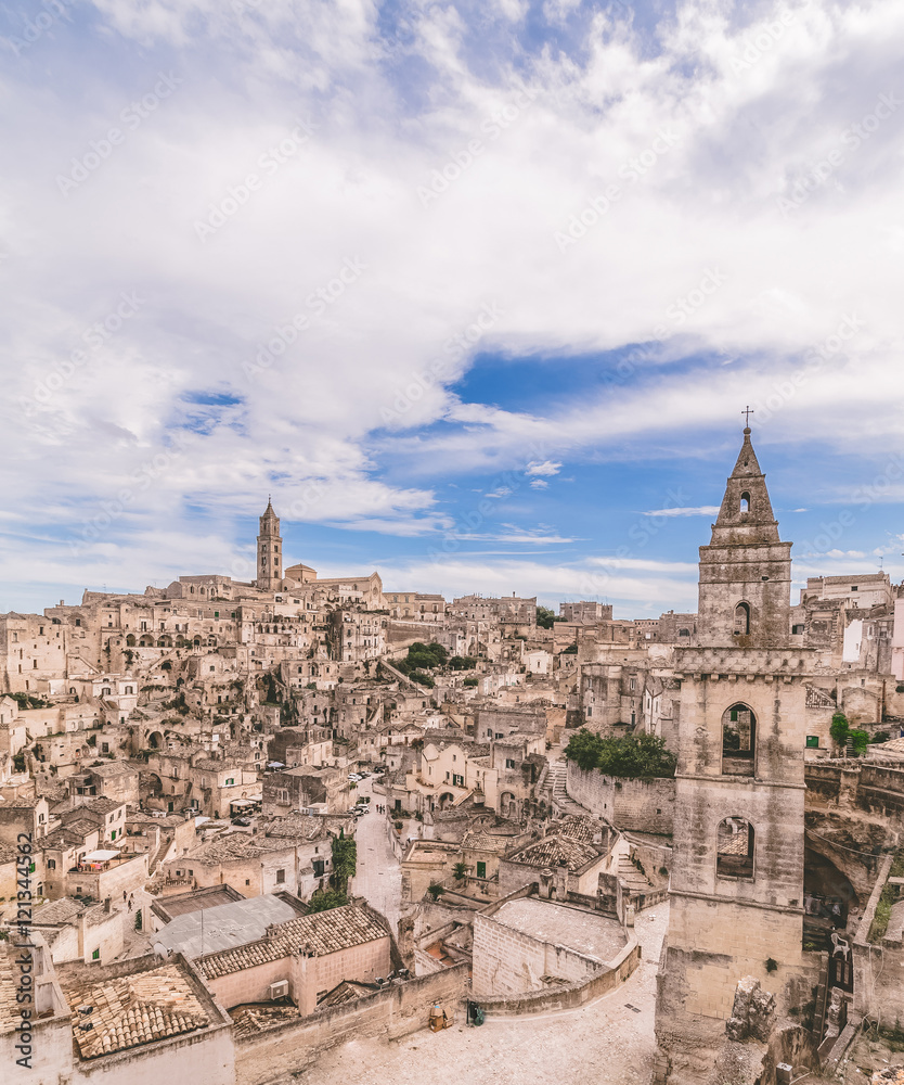 panoramic view of typical stones (Sassi di Matera) and church of Matera under blue sky