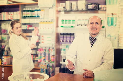 Pharmacist and assistant working at farmacy reception