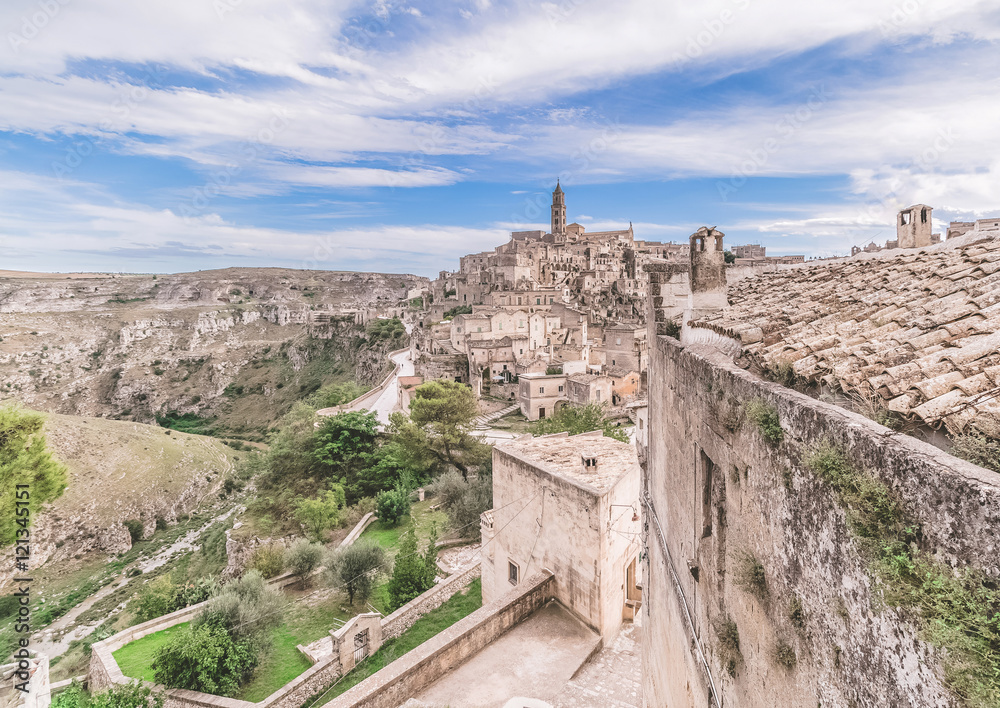 panoramic view of typical stones (Sassi di Matera) and church of Matera under blue sky