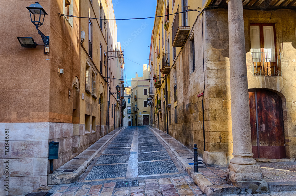 Narrow empty morning street in old part of Tarragona, Spain