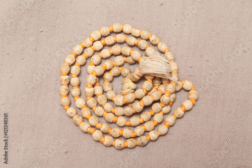 Closeup of rolled chanting beads on woolen texture