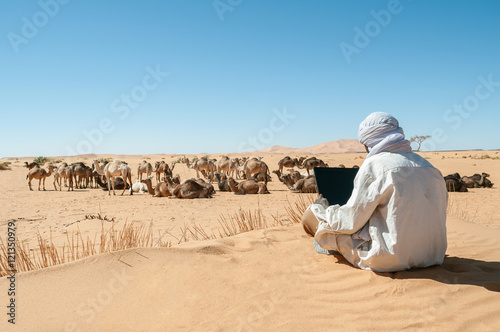 Tuareg browsing internet at Sahara photo
