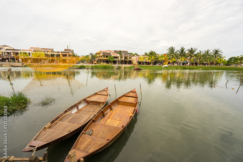 Traditional boats in front of ancient architecture in Hoi An