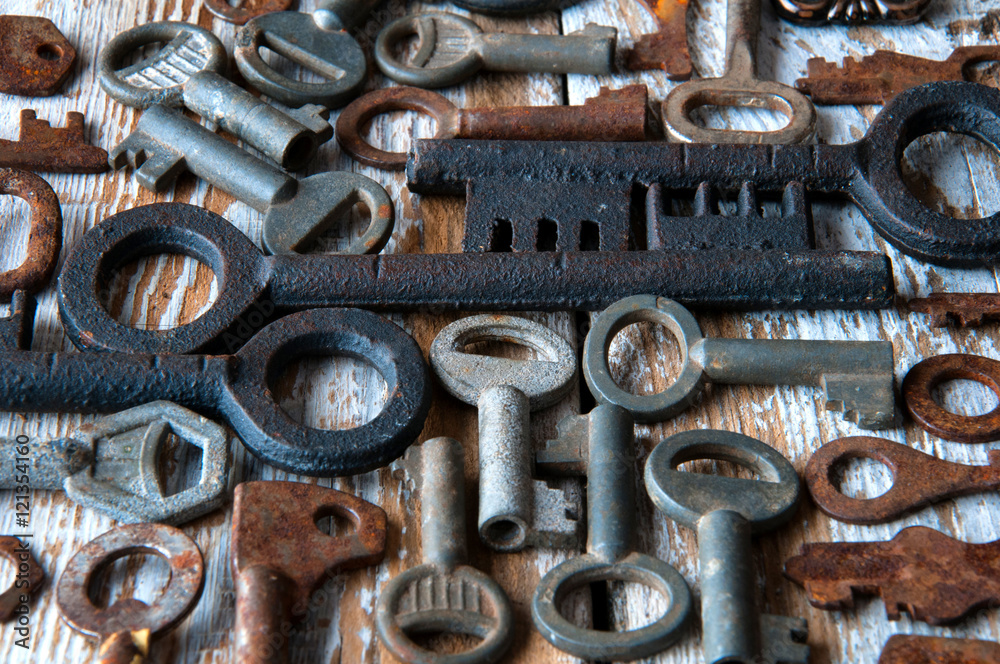 Many rusty keys and padlocks on white wood Many rusty keys and padlocks on white wood