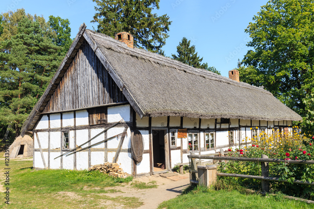 Kluki in polish Pomerania -wooden traditional Polish cottage in Kluki  and colorful flower garden  - obrazy, fototapety, plakaty 