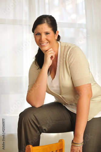 Overweight model smiling in home setting. photo