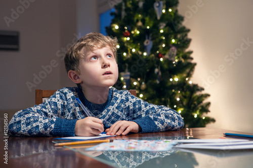 Little boy write Christmas wishes to Santa