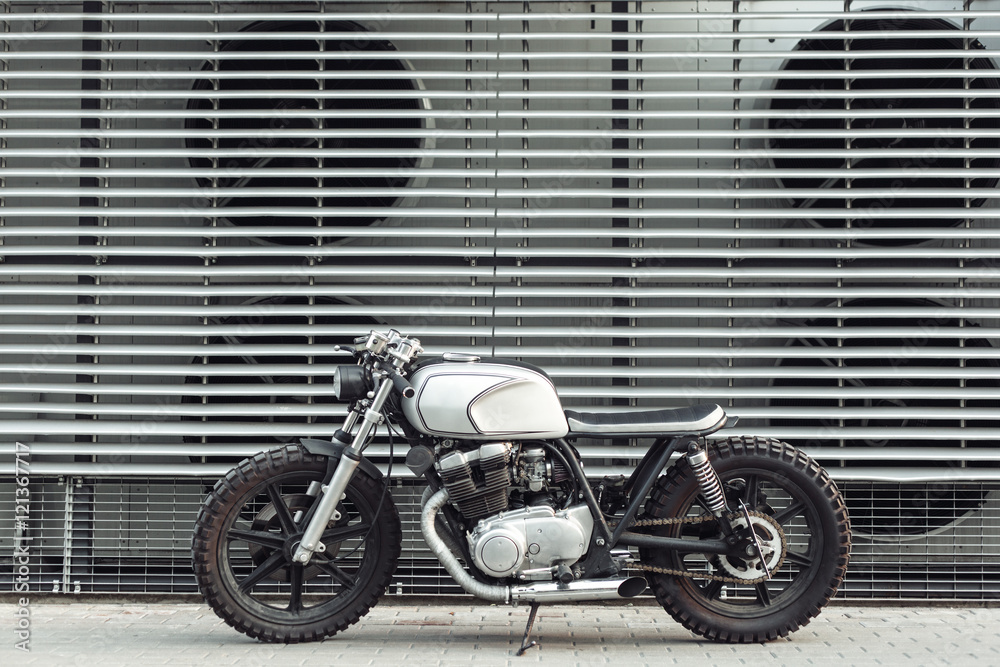 Obraz premium motorcycle standing in dark building in rays of sunlight