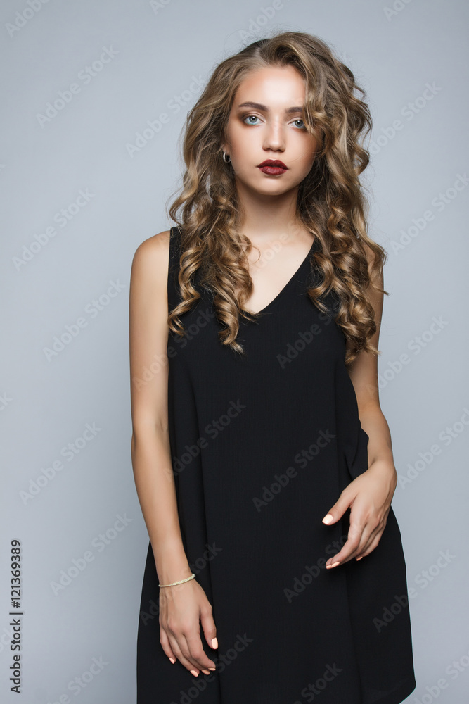Stylish beautiful girl in a black dress in the studio isolated. Stylish beautiful girl in a black dress in the studio isolated.