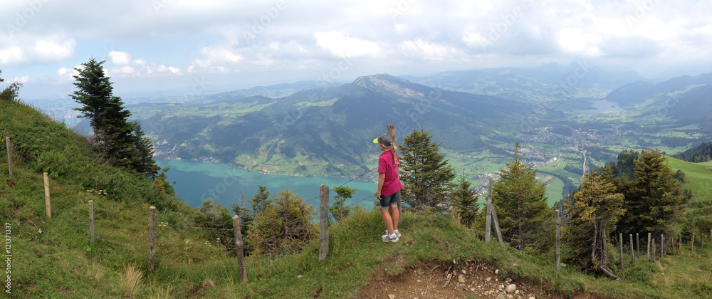 YOUNG HIKING GIRL ENJOYING THE VIEW FROM MOUNT PILATUS TO LAKE LUCERNE SWITZERLAND